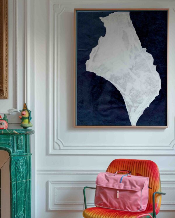 imagen del la lámina enmarcada en el salón con mochila en silla